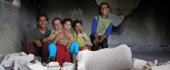 Palestinensian children sitting inmidst of a ruin